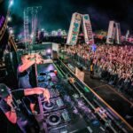two men playing DJ controllers at night time